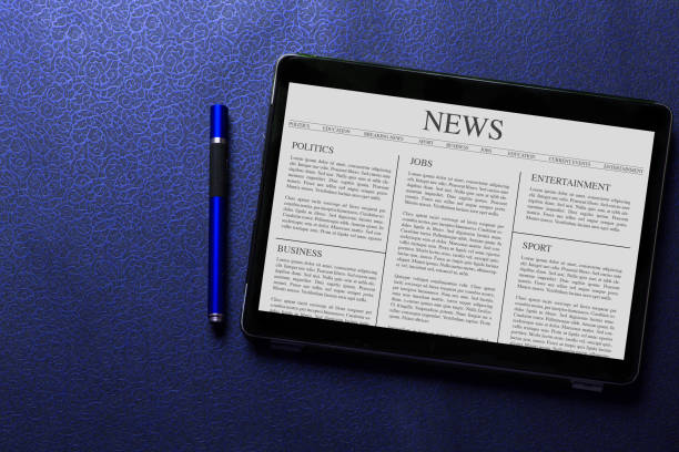 istock News article concept on tablet screen with blue pen on blue pattern textured background 1012900178