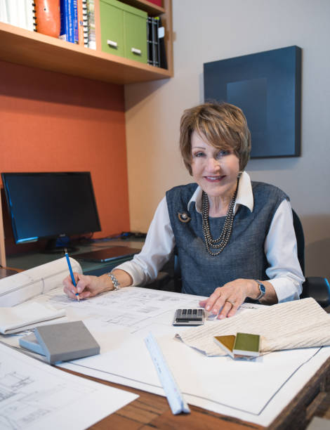 istock Senior woman working in interior design office working on plans 1012906602