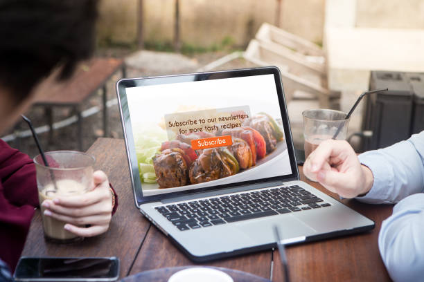 Group of young people having discussion for doing subscribe food blog using laptop / computer at the outdoor cafe