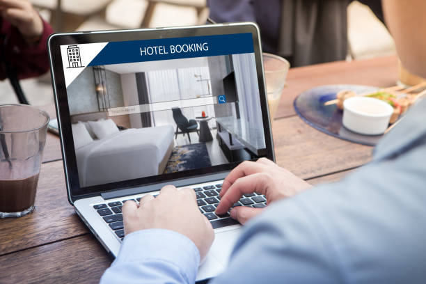 istock Businessman searching for lodging using online web service, booking a hotel on website using laptop / computer at the outdoor cafe 1012916074