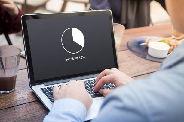 istock Businessman waiting for installing update with circle load percentage waiting indicator concept using laptop / computer at the outdoor cafe 1012916122