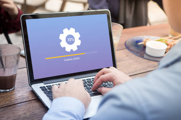 istock Businessman waiting for installing update process with gearbox percentage progress and loading bar on laptop / computer at the outdoor cafe 1012916300