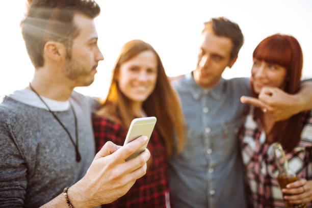 istock friends toasting beer at the park and take a selfie 1012916548