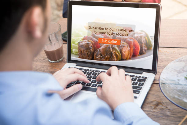 istock Young man doing subscribe food blog using laptop / computer at the outdoor cafe 1012916716