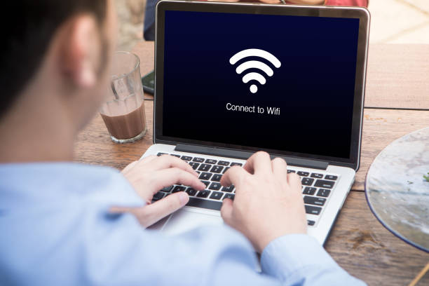 istock Young man working and waiting for wi-fi connection using laptop / computer at the outdoor cafe 1012916724