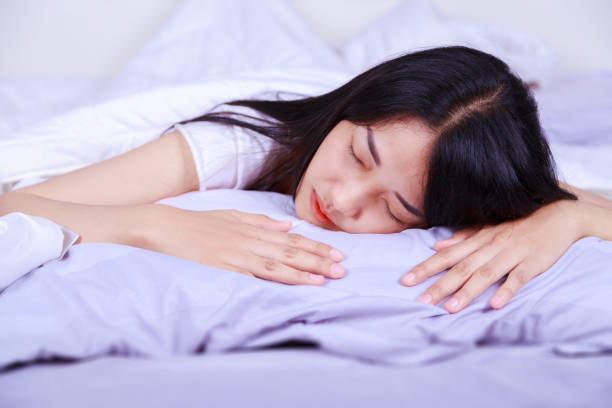istock woman sleeping on bed in bedroom 1012948136
