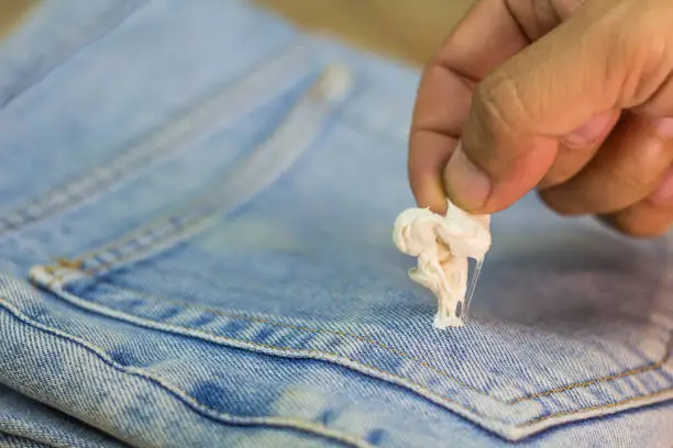 Photo of Gum sticking on jean with holding hand to remove, this is so bad for morning day