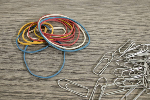 istock Many rubber bands and clasps on a wood table composition 1012964122