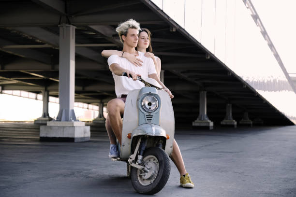 istock Young beautiful couple riding on old scooter 1012967562