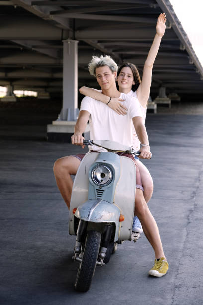 istock Young beautiful couple riding on old scooter 1012967564