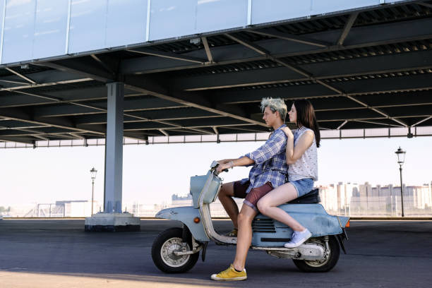 istock Young beautiful couple riding on old scooter 1012967566