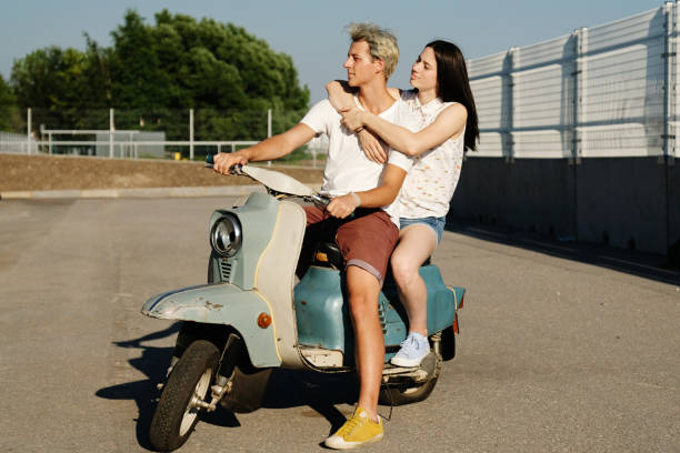 istock Young beautiful couple riding on old scooter 1012967590