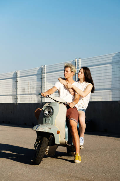 istock Young beautiful couple riding on old scooter 1012967604