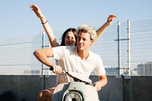 Young beautiful couple riding on old scooter. Motorbike, summer, traveling, smiling, happy, having fun, enjoying in trip. Adventure and vacations concept.