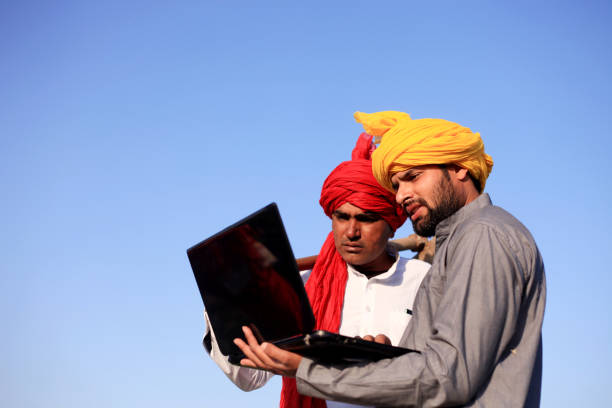 istock Two farmer using laptop outdoor in the nature 1012986208
