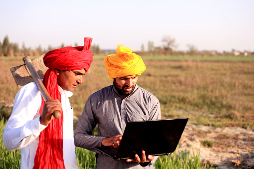 Dos agricultores utilizando portátil al aire libre en la naturaleza photo