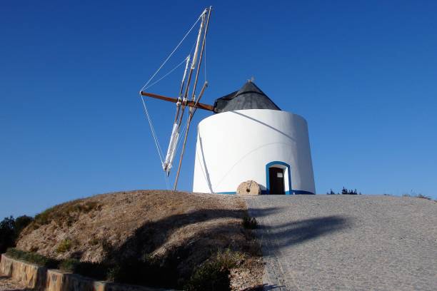 istock Portuguese white windmill with blue, sunny sky in the background in Odeceixe 1012999082