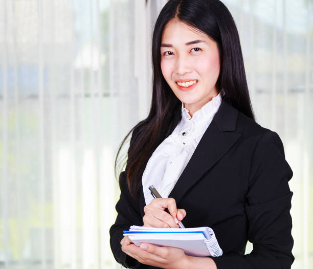 istock business women standing and writing down on notebook 1012999726