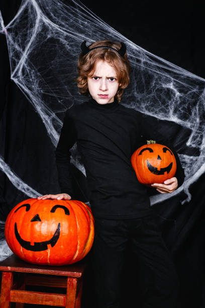 istock A young boy in halloween costume with pumpkins having fun 1013005560