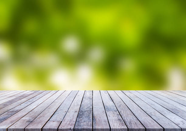 istock Wood plank with abstract green blurred background for product display 1013016186