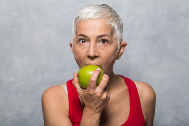 istock Older woman biting an apple 1013022106