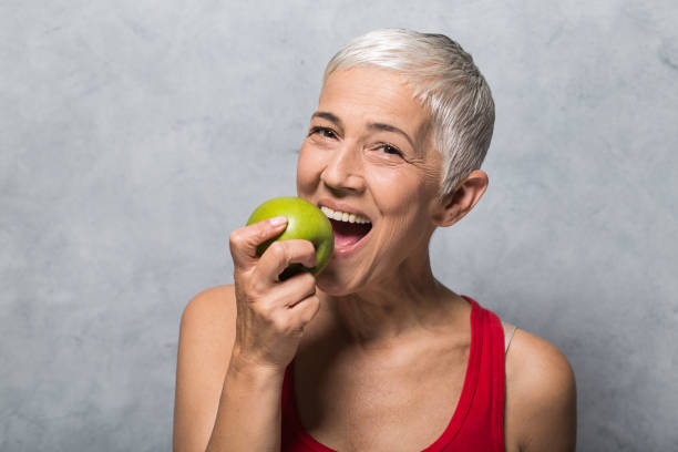 istock Smiling woman eating green apple 1013022128