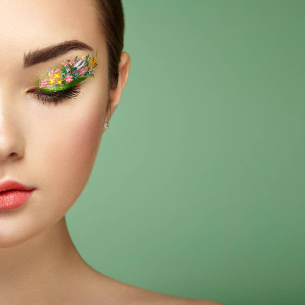 istock Young beautiful woman with flower makeup eyes 1013022452