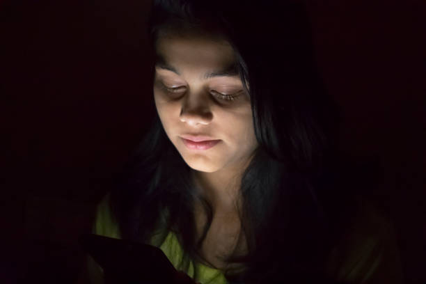 istock teenager girl using phone at night 1013023132