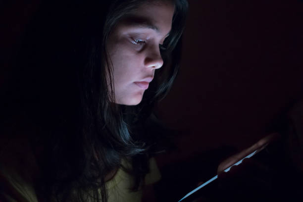 istock teenager girl using phone at night 1013023140