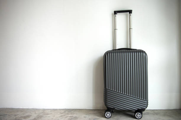 istock Black luggage trolley wheel on the white wall with copy space 1013043350