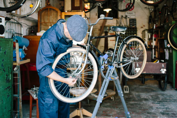 istock hobby mechanic in overall repairs a bicycle in his workshop 1013043432
