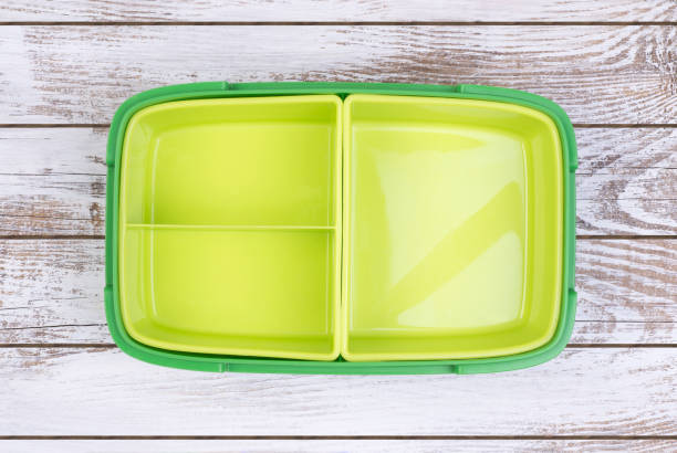 Empty lunch box on wooden table Empty, green, plastic lunch box on wooden table, top view lunch box stock pictures, royalty-free photos & images