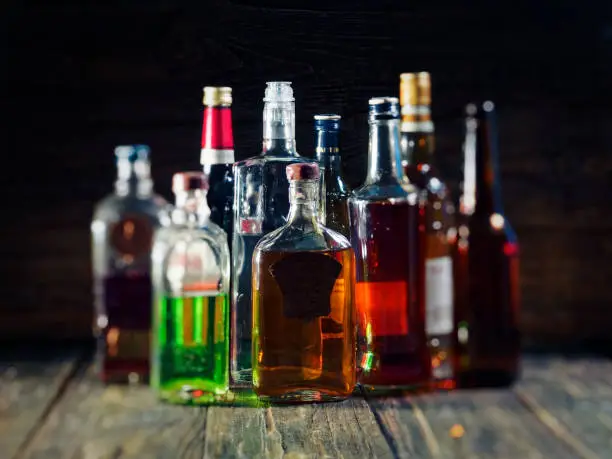 Group of various bottles of alcohol on the wooden bar counter