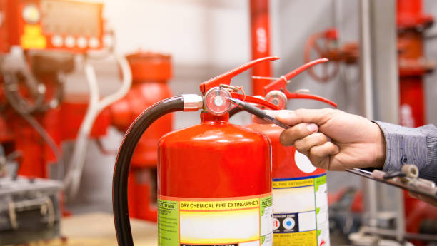 инженер осмотрит огнетушитель в диспетчерской. - fire extinguisher office safety protection стоковые фото и изображения