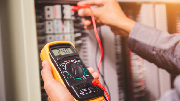 Engineer is measuring voltage or current by voltmeter in control panel stock photo