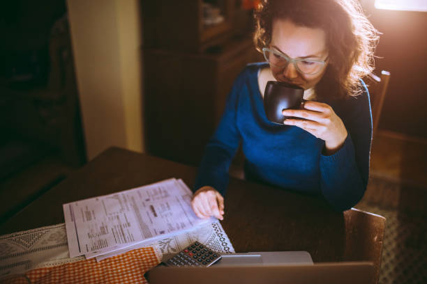 istock Woman going through bills and drinking coffee 1013074704