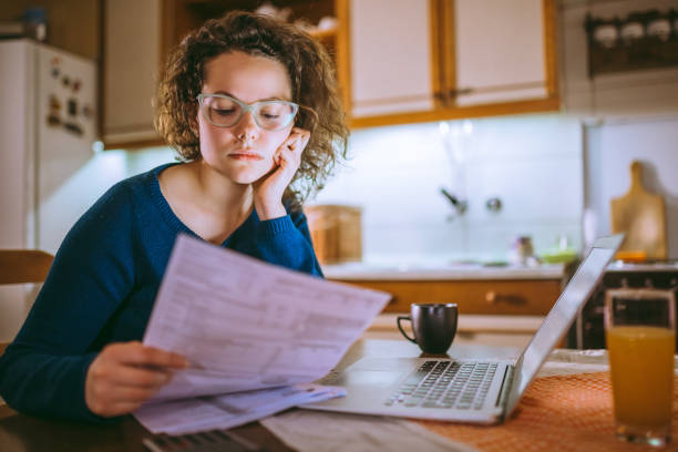 istock Woman going through bills, looking worried 1013077040