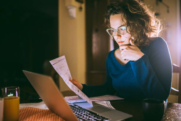 istock Woman going through bills, looking worried 1013077096