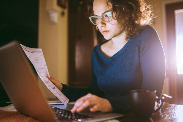 istock Woman going through bills, looking worried 1013077348