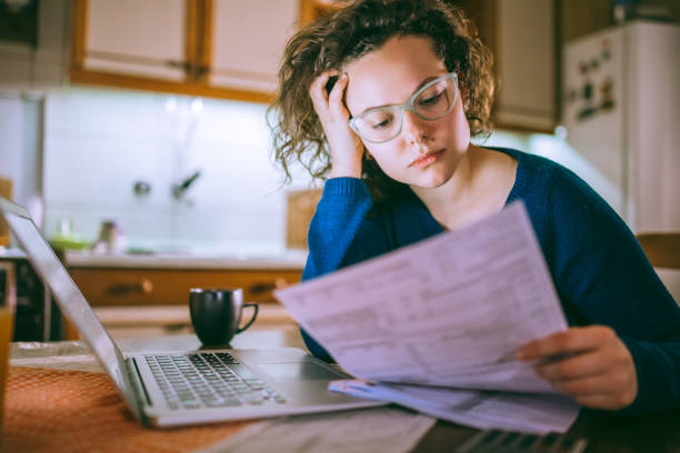 istock Woman going through bills, looking worried 1013077570