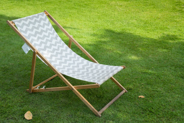 istock white and black striped deckchair on green grass in garden 1013083380
