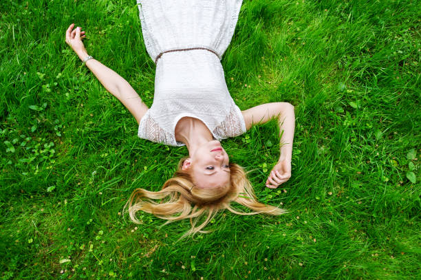 istock Beautiful young woman lying on the bright green grass. 1013086416
