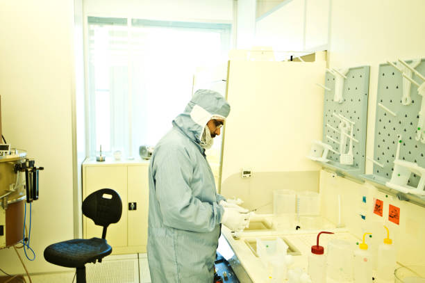 istock Asian Research Scientist Rinsing/Etching Semiconductor Wafer - After Chemically Developing Photoresist & Lift Off Process 1013086622