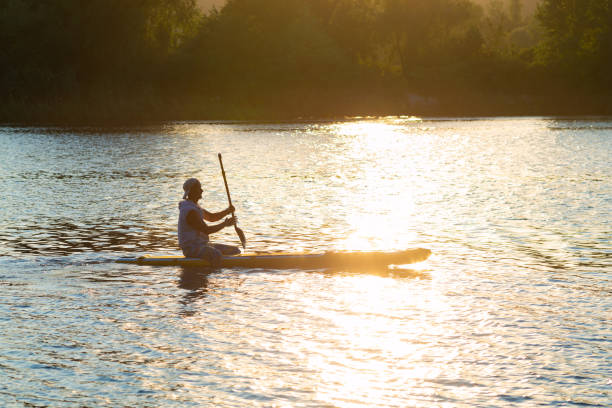 istock Sup surfer sits on the sup board in the golden light 1013090030