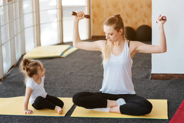 istock Mom and daughter together perform different exercises 1013100388