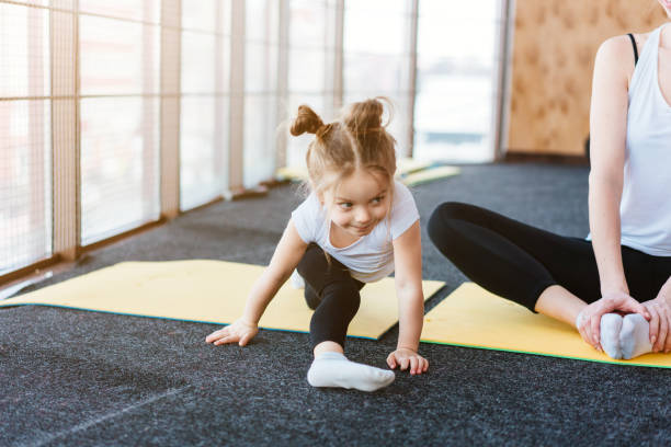 A little girl repeats exercises for her mother stock photo