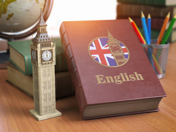 étudier et apprendre le concept anglais. réservez avec le drapeau de la grande-bretagne et big ben tour sur la table. - langue anglaise photos et images de collection