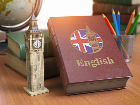 Studying and learn English concept. Book with flag of Great Britain and Big Ben tower on the table.