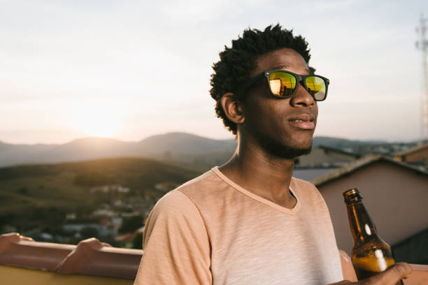 istock Young man drinking a beer on the terrace 1013129220