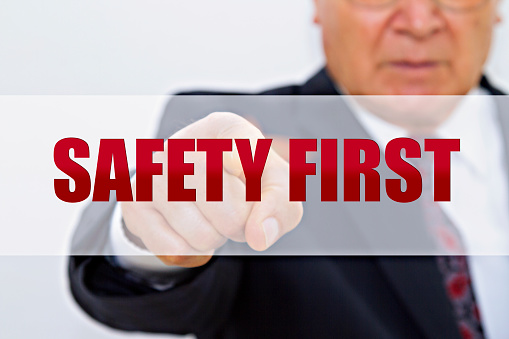 Senior businessman hand showing a message - Safety first.